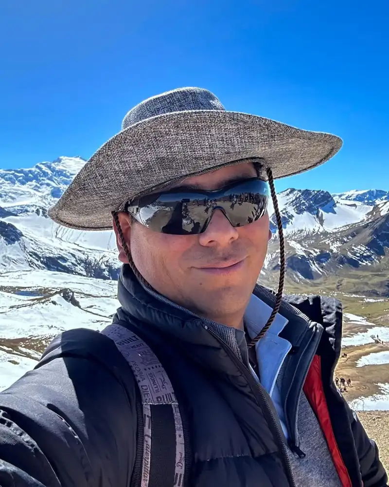 Walter Rodriguez Mozo in the Andes near Cusco, with snow-capped peaks behind